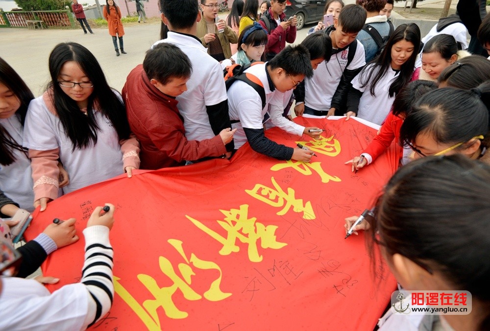 网友们在“网友看新洲”旗帜上专注地签上自己的名字。影隐摄