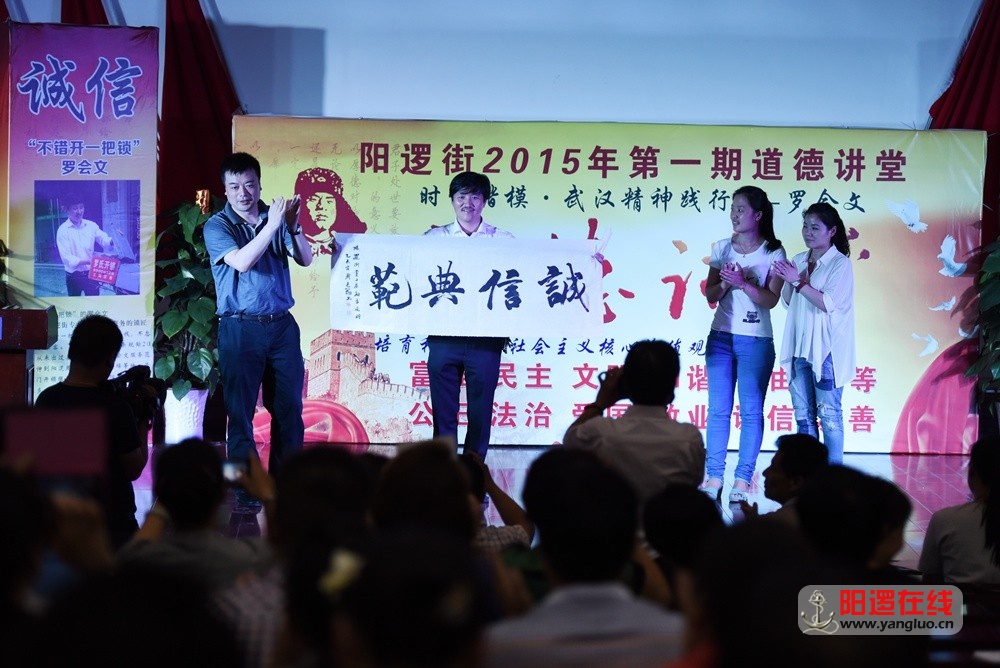 阳逻街党工委书记余建军为罗会文赠送书法“诚信典范”.jpg